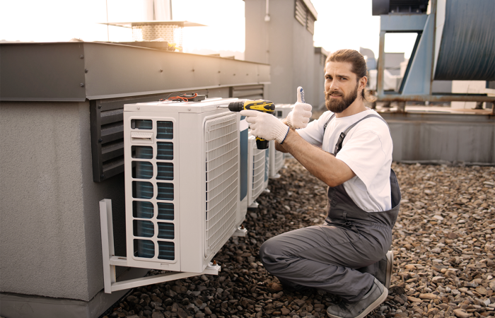 Heating and Air Conditioning Mid Sized HVAC Business Owner Servicing a Rooftop Unit